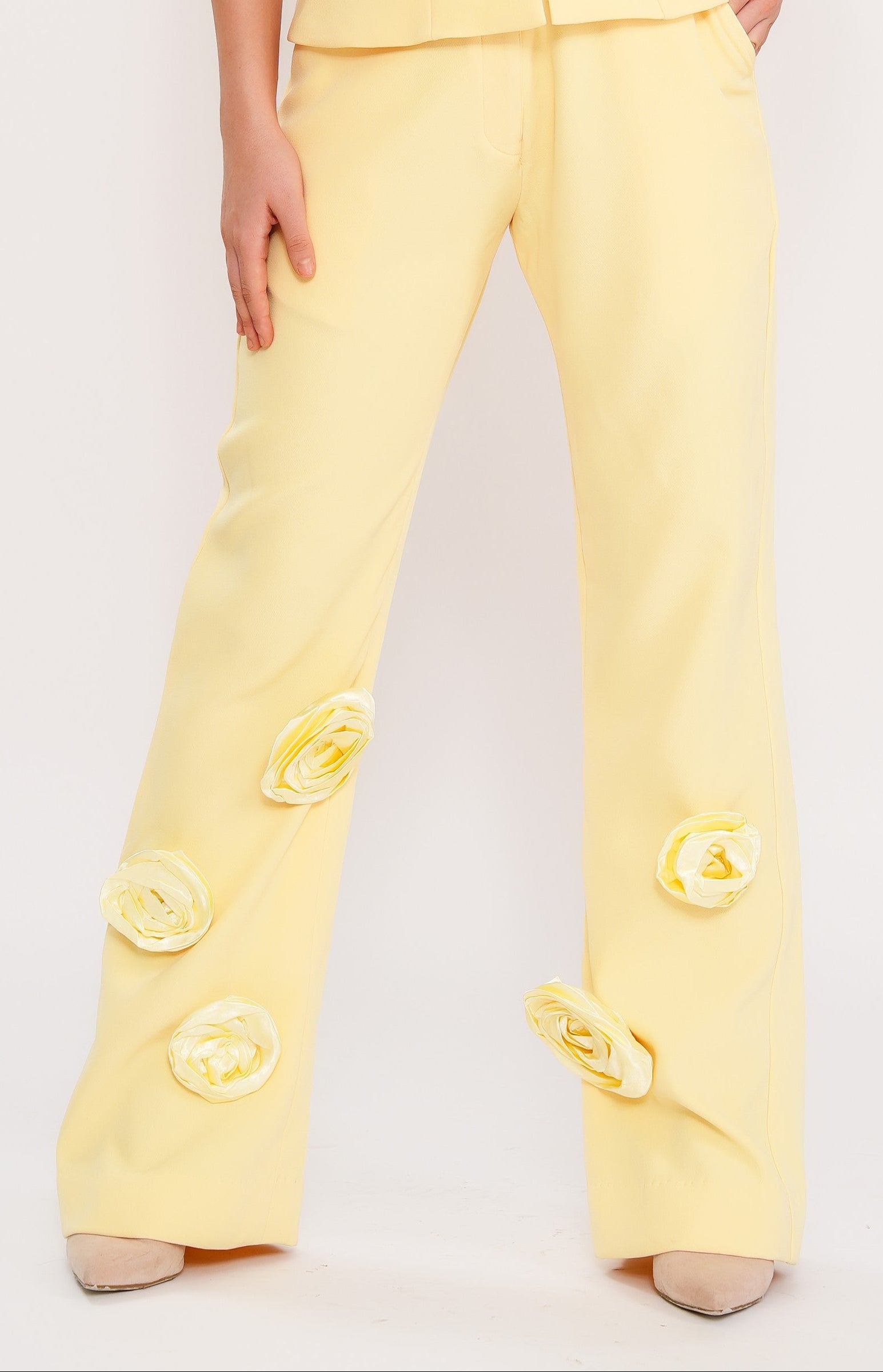 Woman wearing a yellow outfit with button details on a light gray background