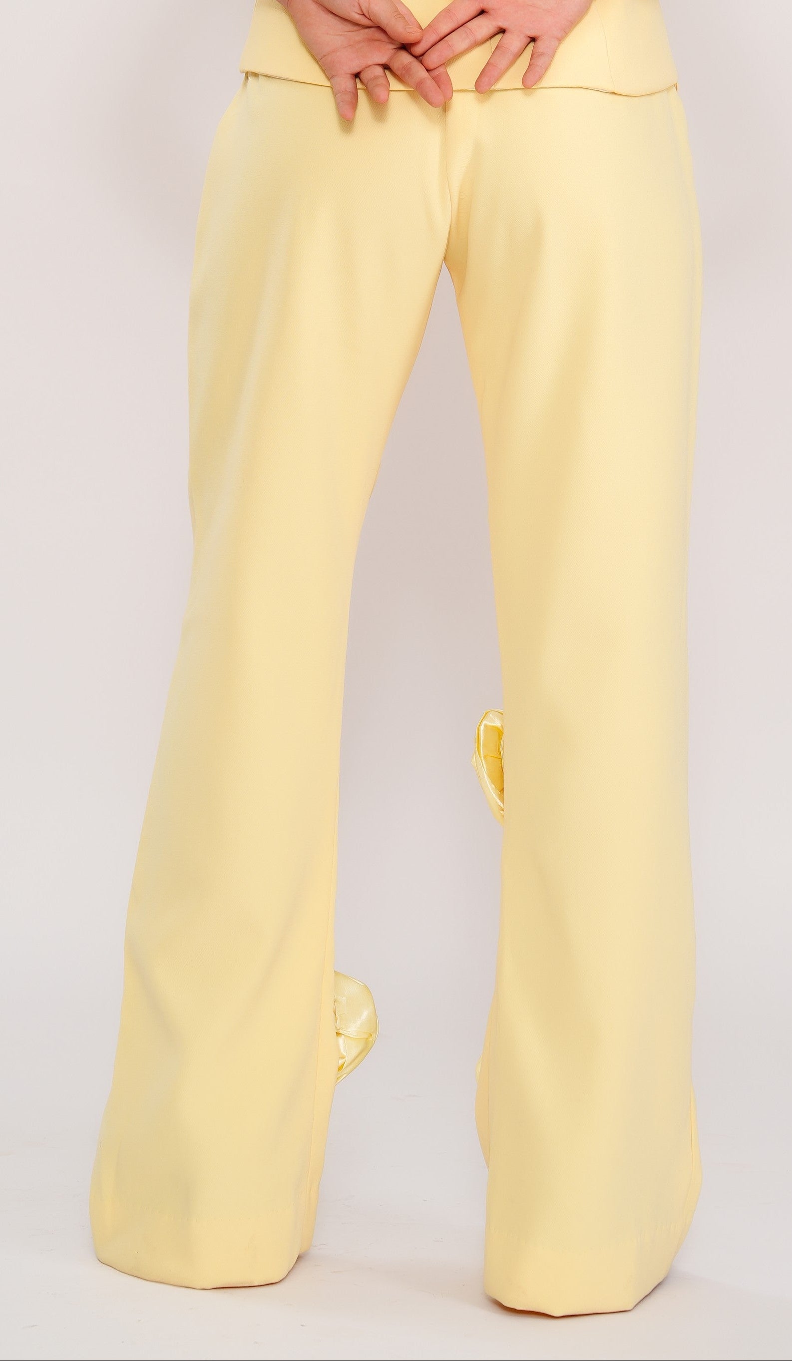Woman wearing a yellow pants on a plain background