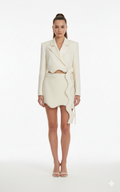 Woman wearing a cream-colored outfit on a white background
